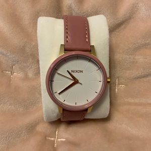 Pink Nixon watch. Gold hardware and white face.